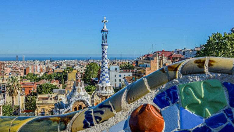 Veduta di Barcellona dal Parco Güell con mosaici colorati e città sul mare