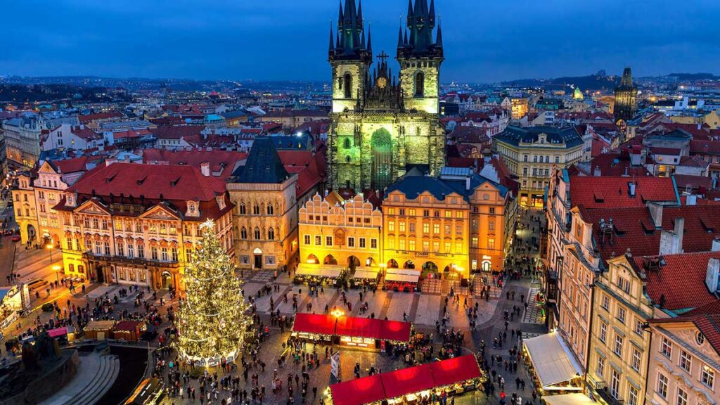 Foto di viaggio a Praga con mercatini di Natale, luci nel centro storico e atmosfera boema invernale.